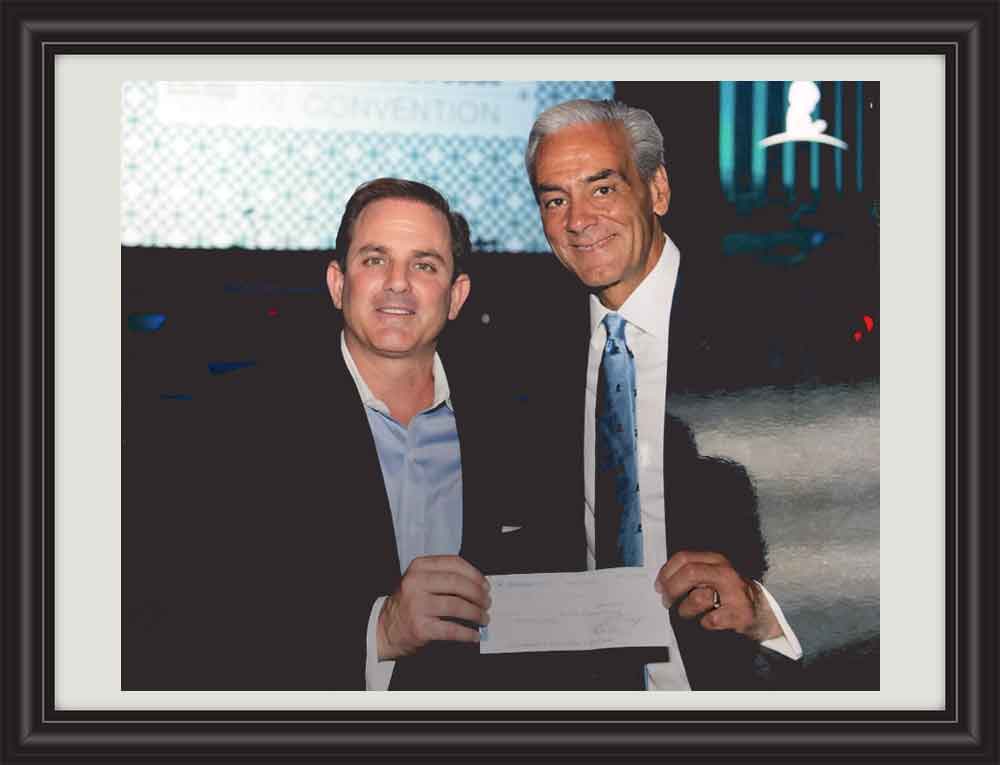 Tom Ganim presents a check for $1-million to St. Jude’s Research Hospital President and CEO Richard Shadyac.